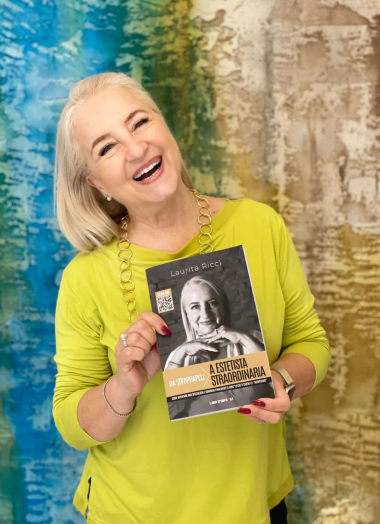 Laurita Ricci con il suo libro "Da Strappapeli a Estetista Straordinaria" in mano